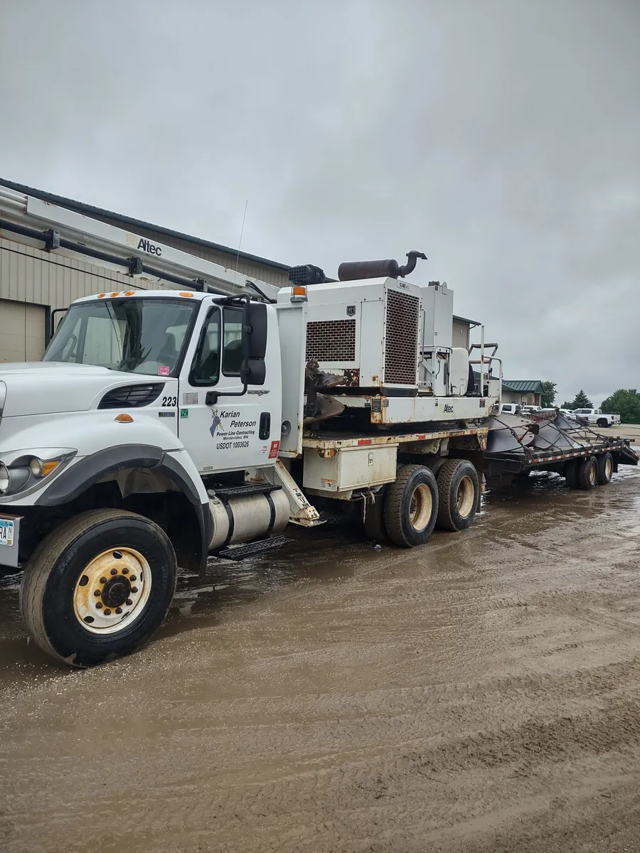 A Karian Peterson bucket truck and trailer at the company yard